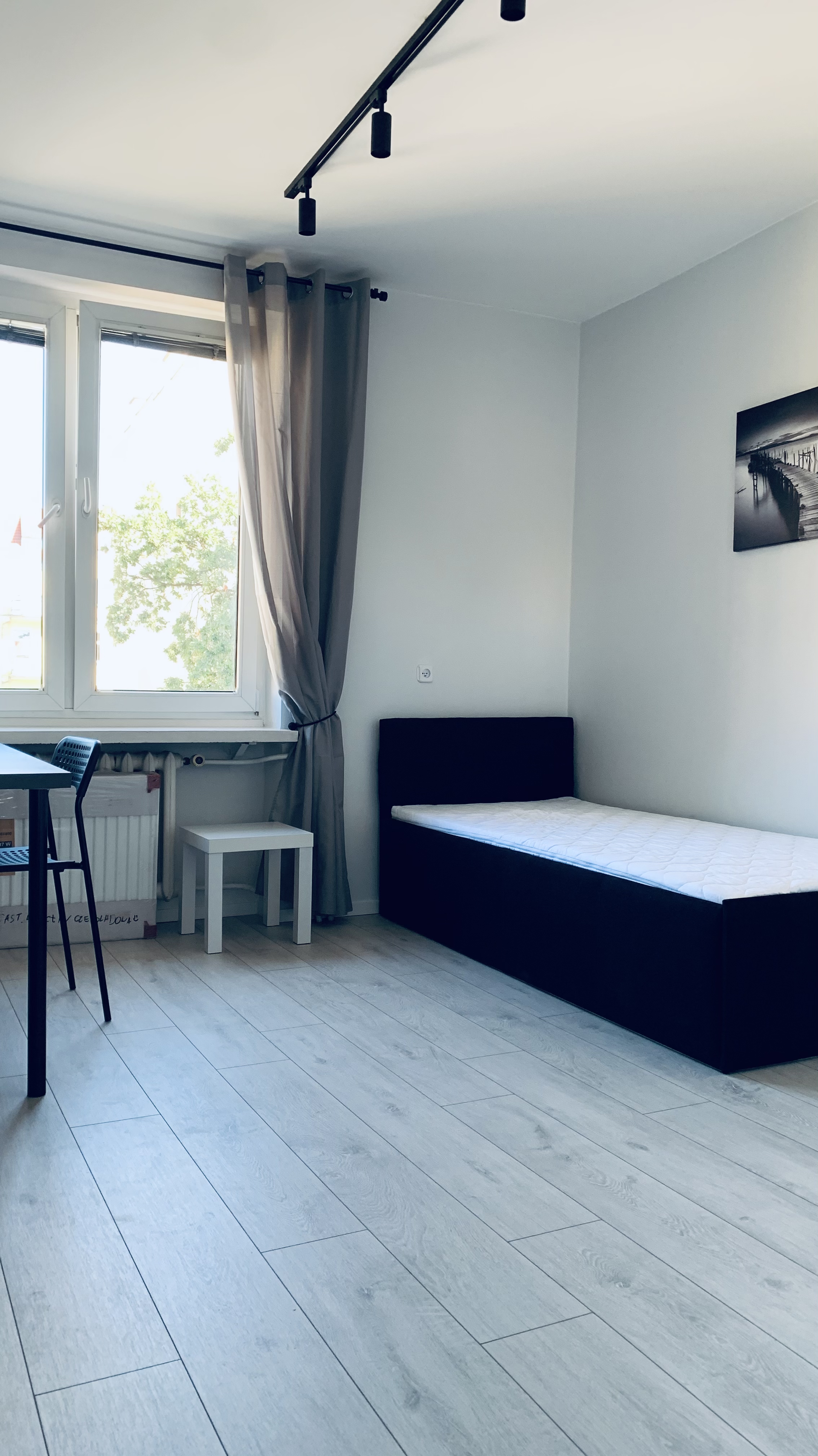 Bed, window and workspace in Borowska room #3