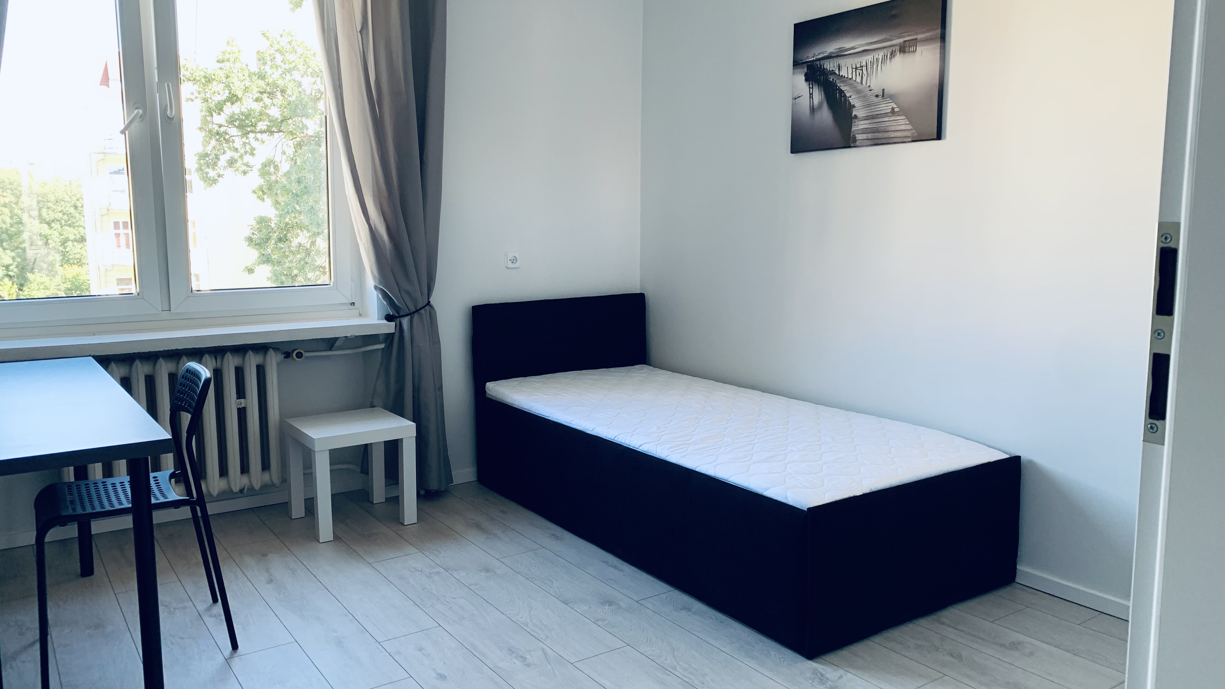 Bed and window in Borowska room #3