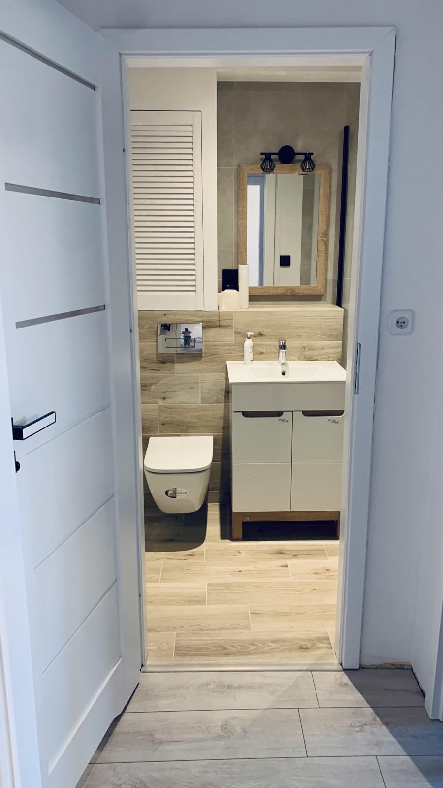 View into the shared bathroom from the hallway in the Borowska apartment
