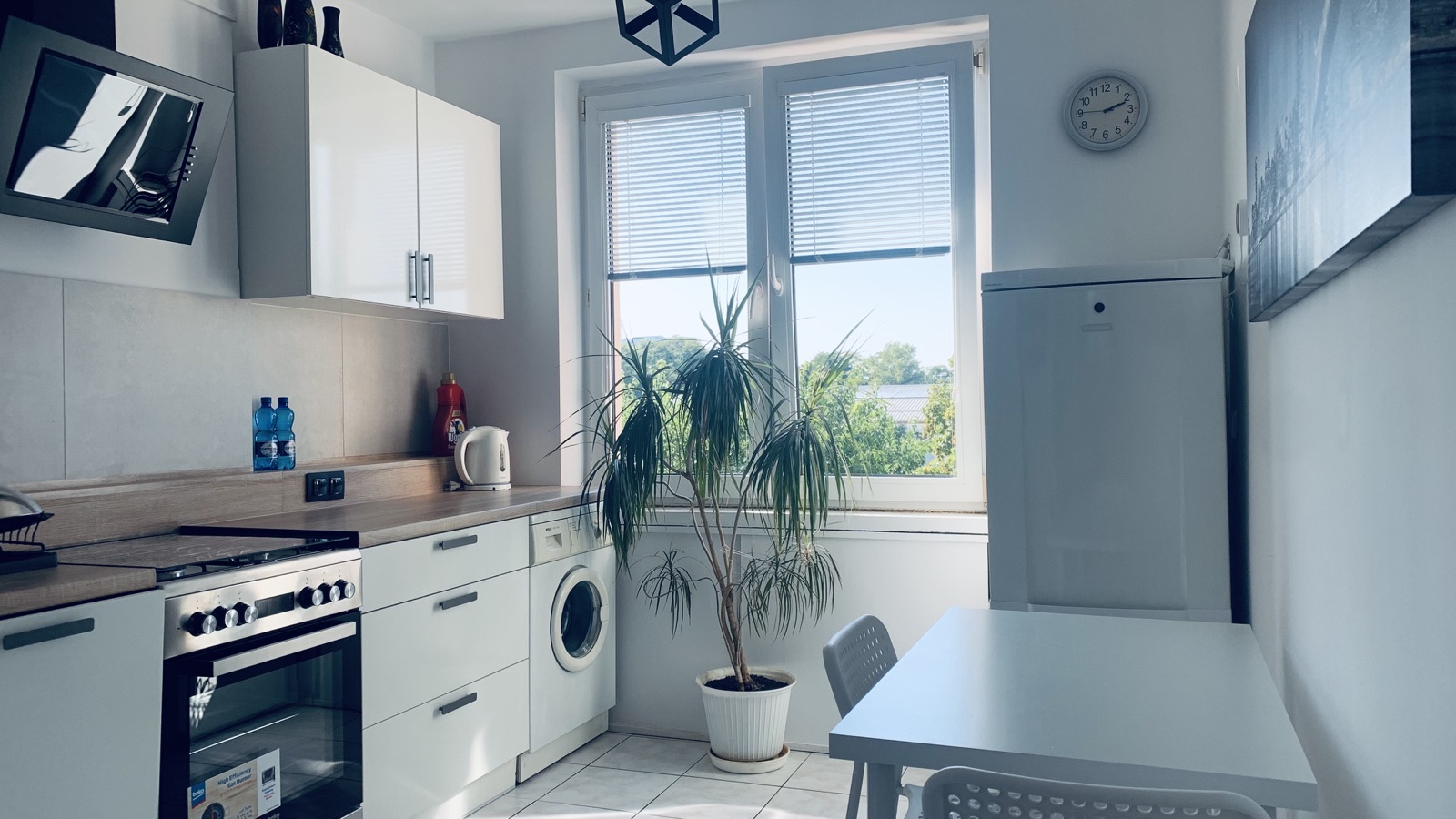 Kitchen appliances and dining table in the shared Borowska apartment kitchen