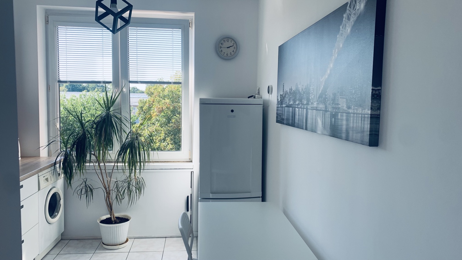 Dining table and refrigerator in the shared Borowska apartment kitchen